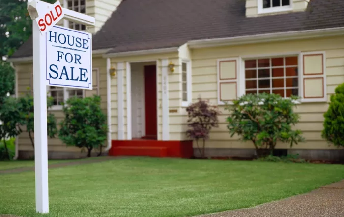 Home with a for sale sign in front